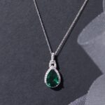1747082106 jewelili 10k white gold 12x8mm pear created emerald ruby sapphire with round created white sapphire and natural white round diamond accent drop pendant necklace.jpg